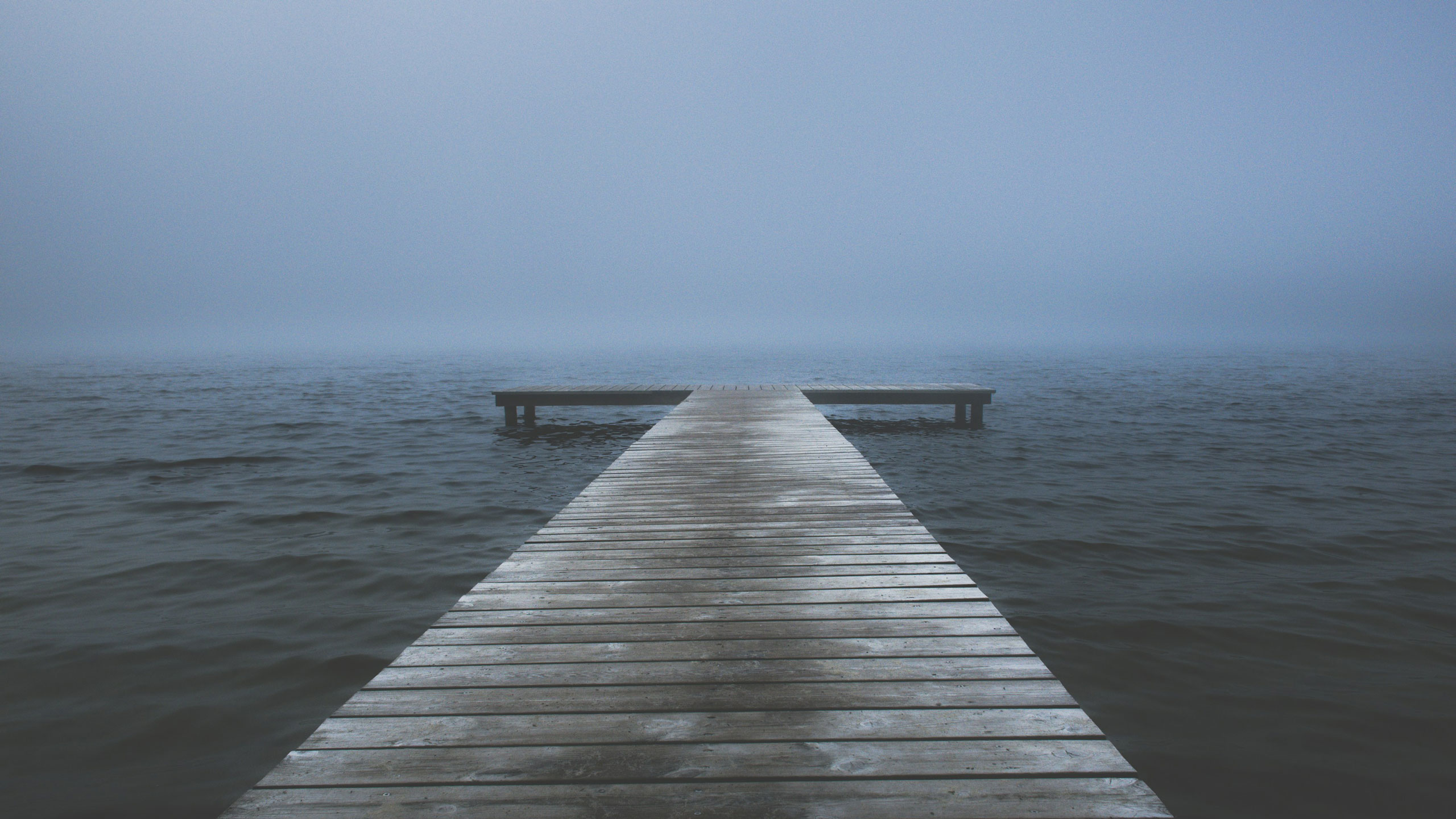 Drewniany pomost nad jeziorem, w oddali mgła
